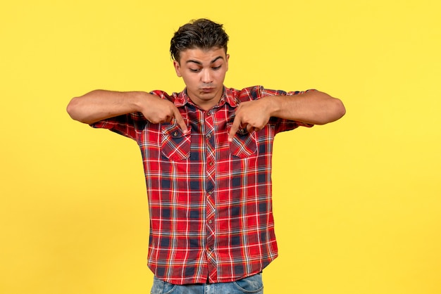 Vue de face jeune homme en chemise lumineuse posant sur fond jaune modèle masculin de couleurs