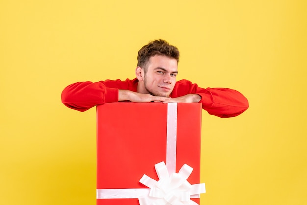 Photo gratuite vue de face jeune homme en chemise rouge assis à l'intérieur de la boîte actuelle