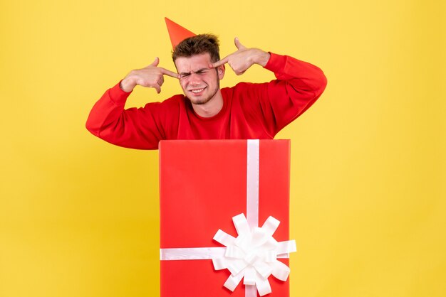 Vue de face jeune homme en chemise rouge à l'intérieur de la boîte actuelle