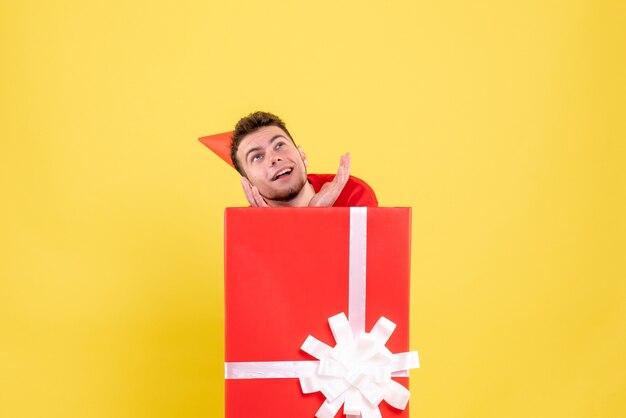 Vue de face jeune homme en chemise rouge à l'intérieur de la boîte actuelle