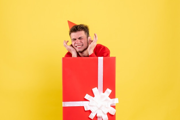 Vue de face jeune homme en chemise rouge à l'intérieur de la boîte actuelle