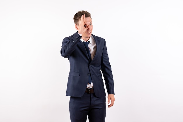 Vue de face jeune homme en costume classique élégant souriant sur fond blanc