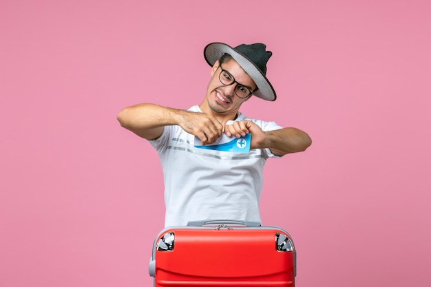 Vue De Face Jeune Homme Déchirant Le Billet D'avion Sur Le Mur Rose Voyage Voyage Avion D'émotion Masculine D'été