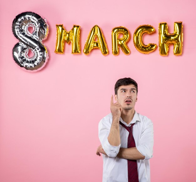 Vue de face jeune homme avec décoration de mars sur fond rose couleurs mariage féminin femmes jour présent homme mari parti égalité