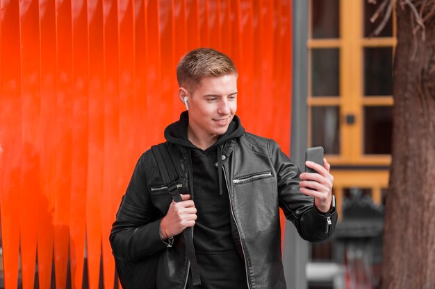 Vue de face jeune homme écoutant de la musique sur les écouteurs à l'extérieur