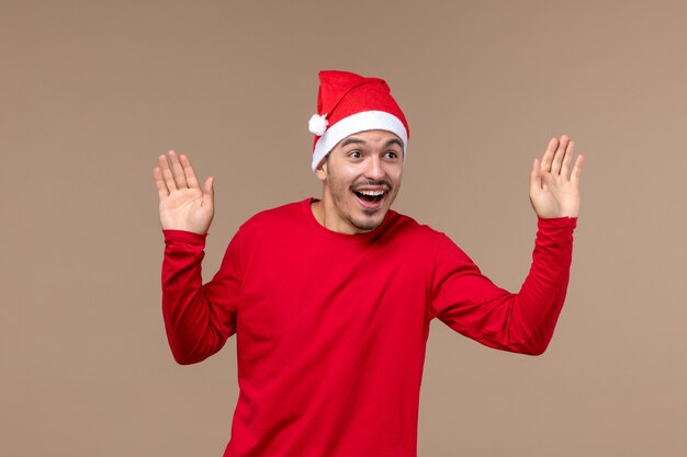 Vue de face jeune homme avec une expression excitée sur un bureau brun émotion masculine de vacances