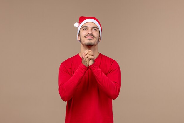 Vue de face jeune homme avec une expression excitée sur le bureau marron vacances d'émotion de Noël