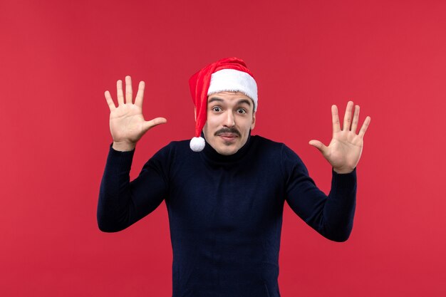 Vue de face jeune homme avec une expression excitée sur fond rouge