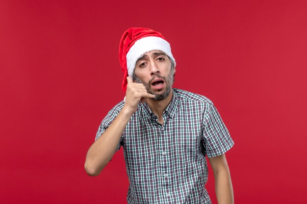 Vue de face jeune homme avec une expression fatiguée sur fond rouge