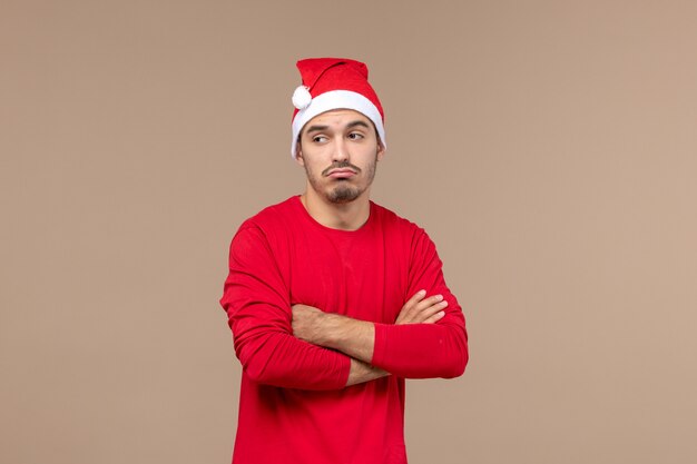 Vue de face jeune homme avec une expression triste sur fond marron émotions vacances couleur mâle