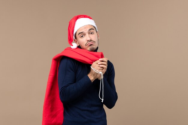 Vue de face jeune homme avec une expression triste, santa de vacances de noël