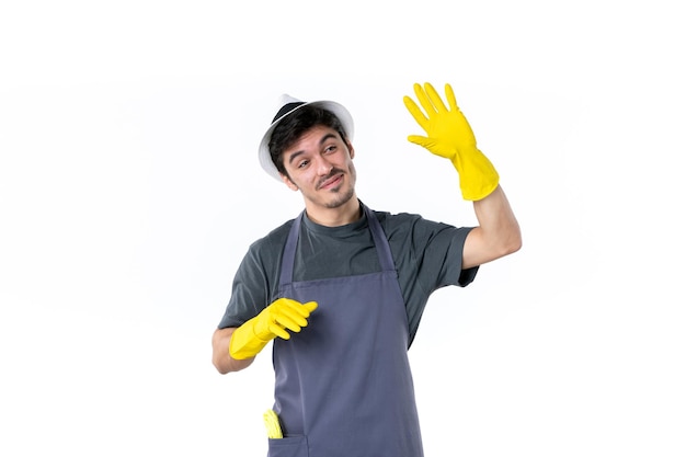 Vue de face jeune homme en gants jaunes sur fond blanc fleur jardinier arbre herbe plante travail jardin