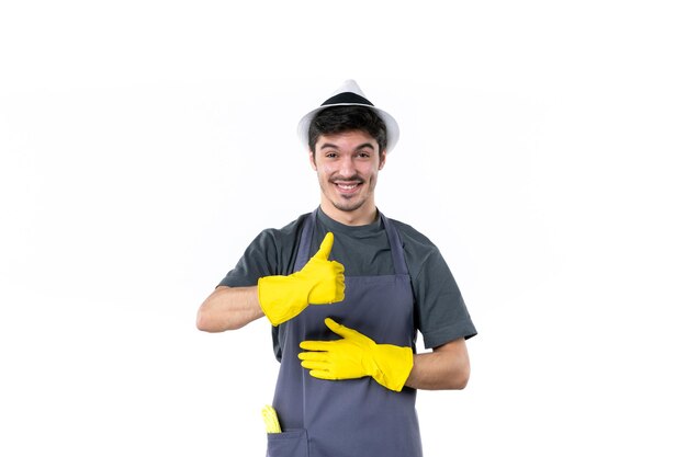 Vue de face jeune homme en gants jaunes souriant sur fond blanc jardinier de fleurs arbre herbe bush usine emploi jardin