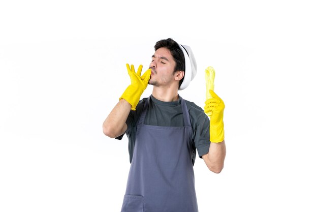 Vue de face jeune homme en gants jaunes tenant des cordes sur fond blanc jardin de fleurs herbe jardinier emploi vert usine de brousse