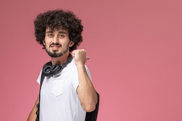 Photo gratuite vue de face jeune homme indiquant sa direction arrière