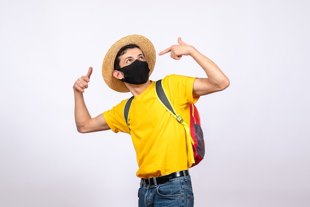 Vue de face jeune homme intelligent avec masque et t-shirt jaune pointant du doigt sur lui-même