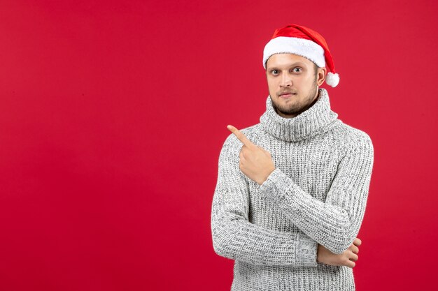 Vue de face jeune homme en jersey chaud sur un bureau rouge