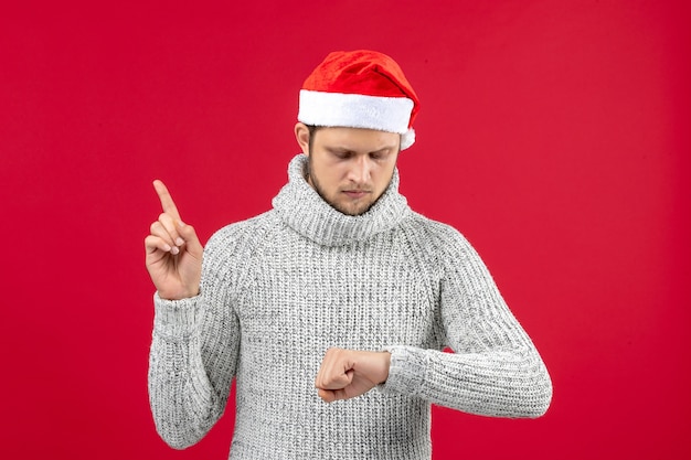 Vue de face jeune homme en jersey chaud sur fond rouge