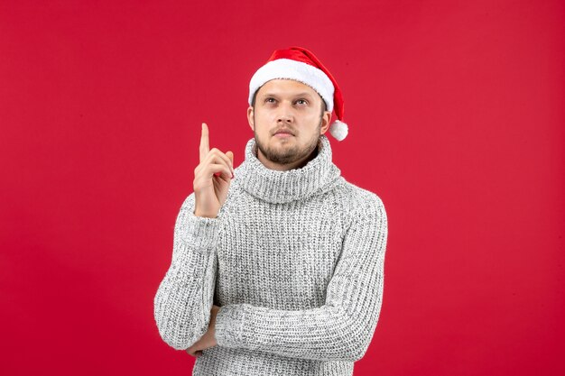 Vue de face jeune homme en jersey chaud sur table rouge