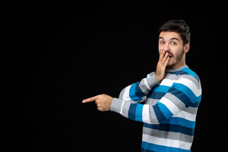 Photo gratuit vue de face jeune homme en jersey rayé bleu sur le mur noir