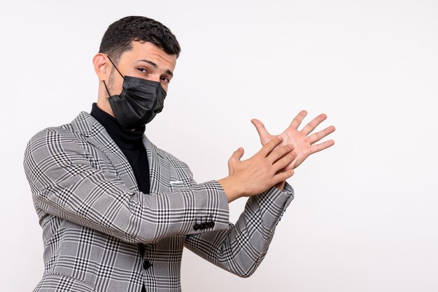 Vue de face jeune homme avec masque noir applaudissant des mains debout sur fond blanc isolé