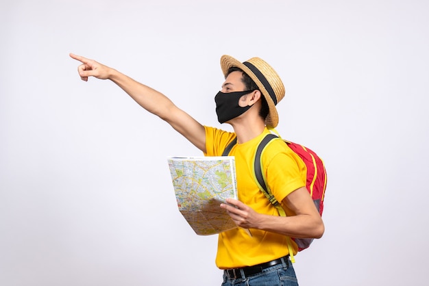 Vue de face jeune homme avec masque et sac à dos rouge pointant quelque chose