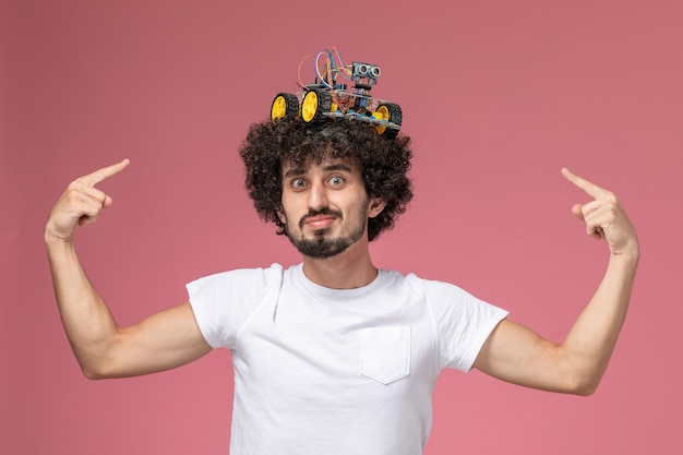 Photo gratuite vue de face jeune homme pointant l'artuino électronique sur sa tête