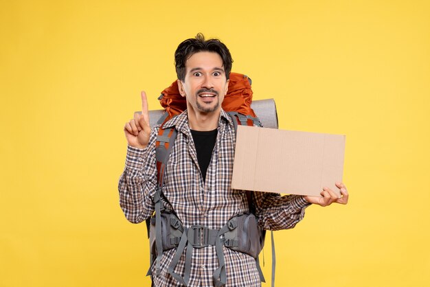 Vue de face jeune homme en randonnée avec sac à dos sur jaune