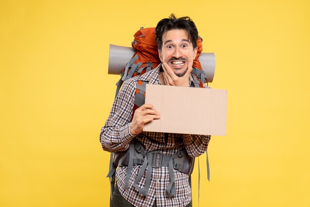 Vue de face jeune homme en randonnée avec sac à dos sur jaune