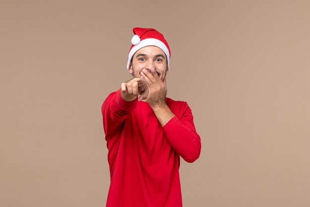 Vue de face jeune homme en riant sur fond marron couleur masculine émotion vacances