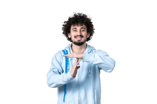 Vue de face jeune homme avec ruban à mesurer faisant t-signe sur fond blanc poids musculaire santé torse minceur mesure de la taille du corps perdant humain