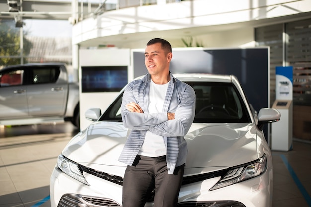 Vue de face jeune homme avec sa nouvelle voiture