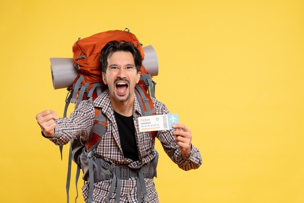 Vue de face jeune homme avec sac à dos holding ticket hurlant sur jaune