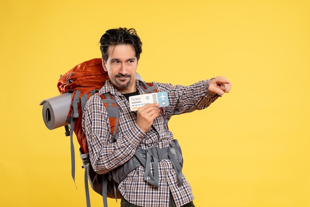 Photo gratuite vue de face jeune homme avec sac à dos tenant un billet sur jaune