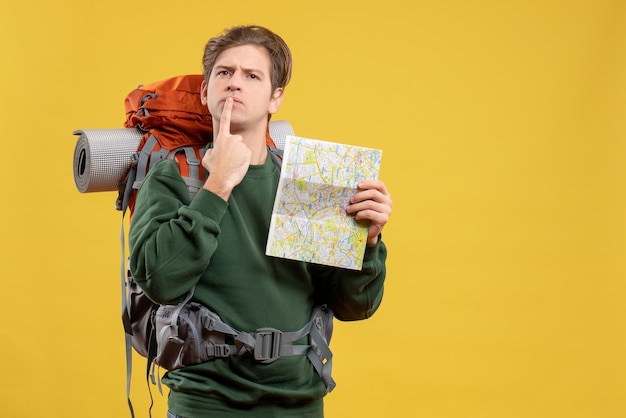 Photo gratuite vue de face jeune homme avec sac à dos tenant la carte