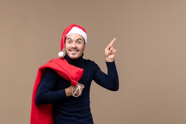 Vue de face jeune homme avec sac présent, émotion vacances noël