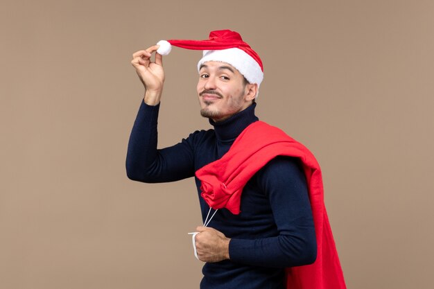 Vue de face jeune homme avec sac présent, vacances noël santa