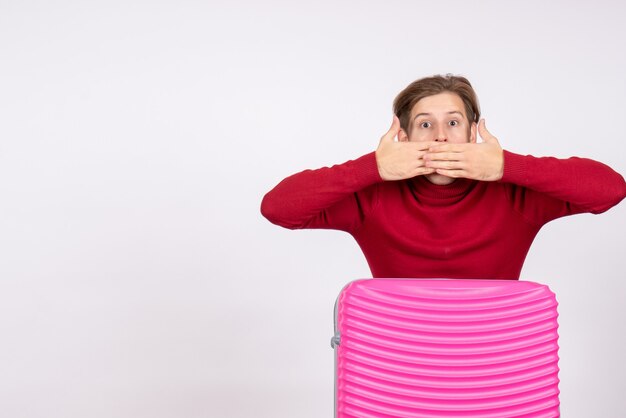 Vue de face jeune homme avec sac rose choqué sur fond blanc