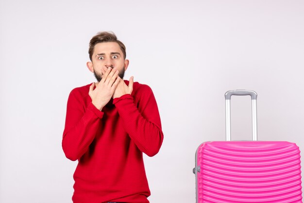 Vue de face jeune homme avec sac rose choqué sur mur blanc photo voyage voyage vacances couleur humaine été voyage