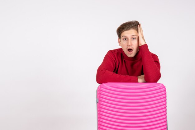 Vue de face jeune homme avec sac rose sur fond blanc