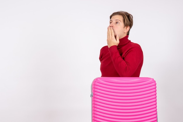 Vue de face jeune homme avec sac rose sur fond blanc