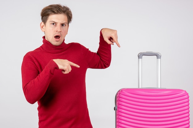 Vue de face jeune homme avec sac rose sur fond blanc