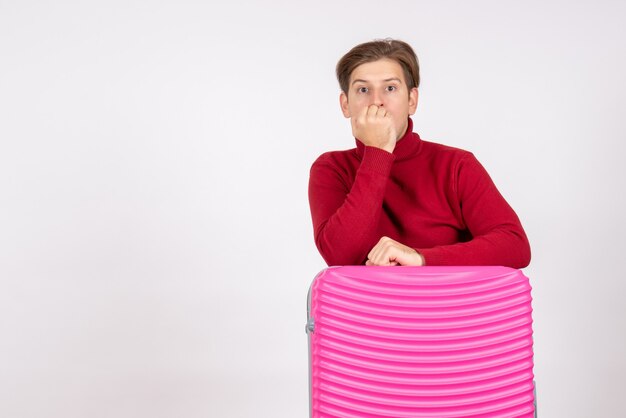 Vue de face jeune homme avec sac rose sur fond blanc