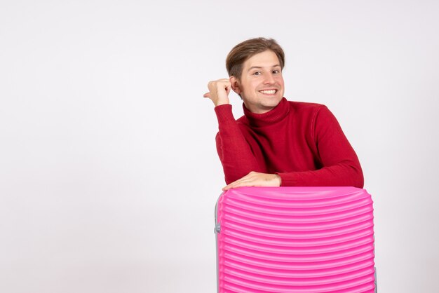 Vue de face jeune homme avec sac rose sur fond blanc