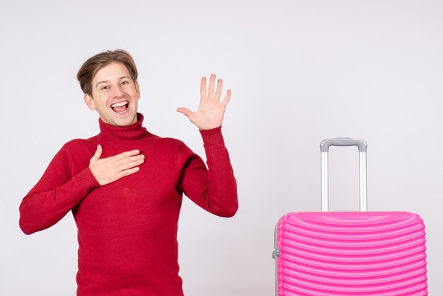 Vue de face jeune homme avec sac rose sur fond blanc