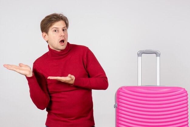 Vue de face jeune homme avec sac rose sur fond blanc