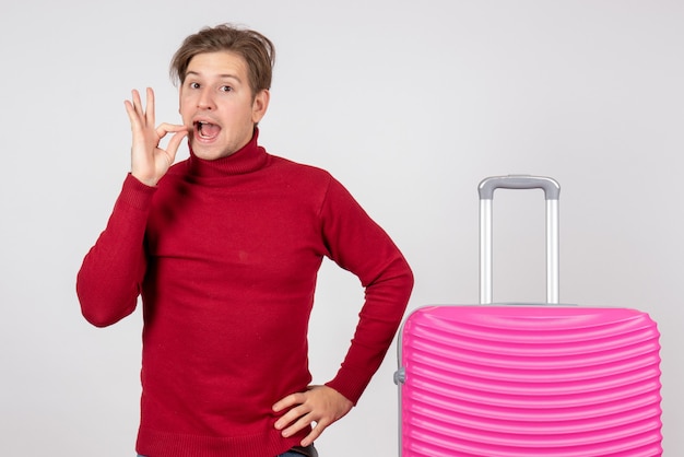 Vue de face jeune homme avec sac rose sur fond blanc