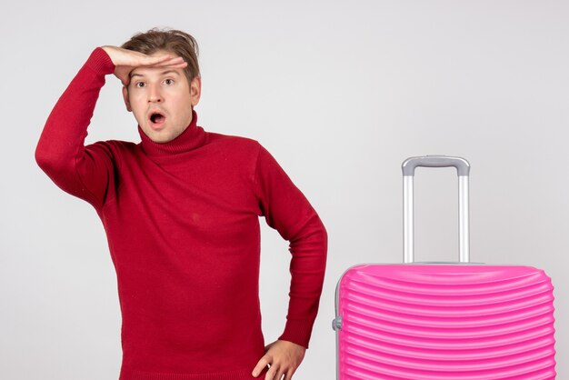 Vue de face jeune homme avec sac rose sur fond blanc