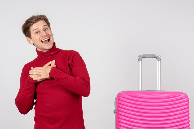 Vue de face jeune homme avec sac rose sur fond blanc