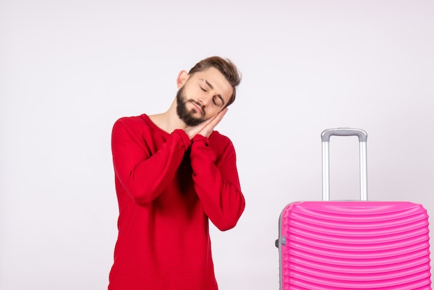 Vue de face jeune homme avec sac rose sur mur blanc photo voyage vacances couleur humaine été vol